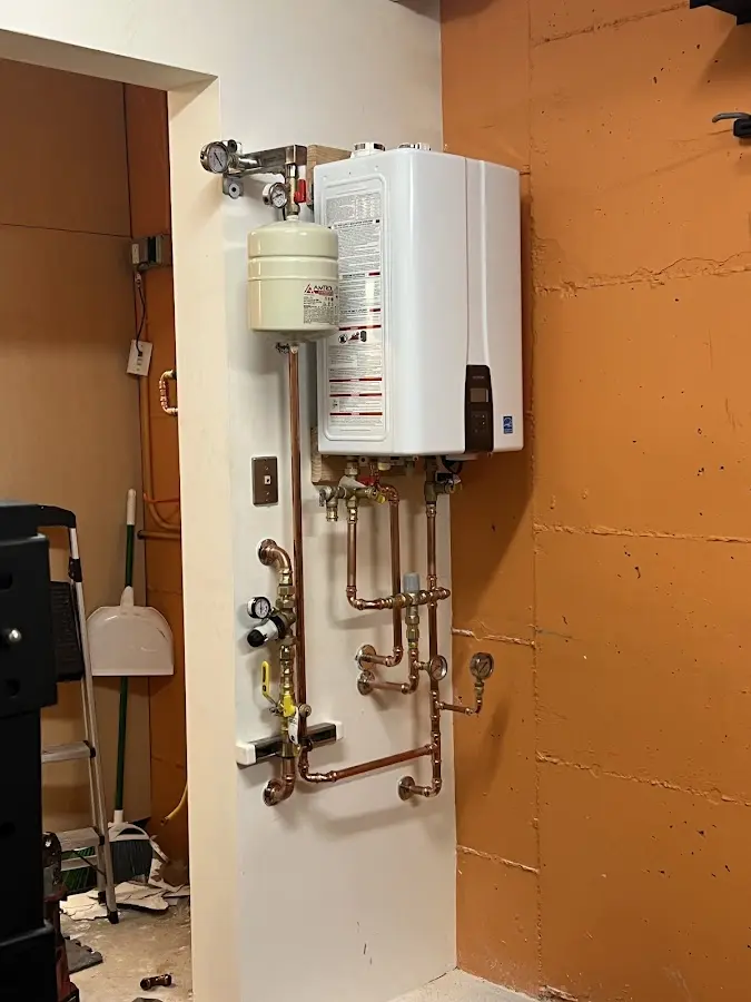Plumbing technician inspecting water heater connections in Kokomo